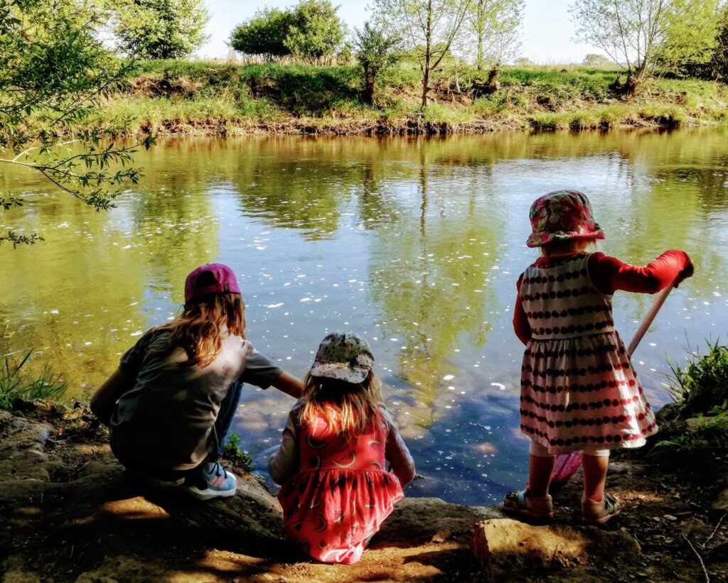 Drei Kinder sammeln beim RuhrCleanUp Müll am Ufer der Ruhr in Schwerte