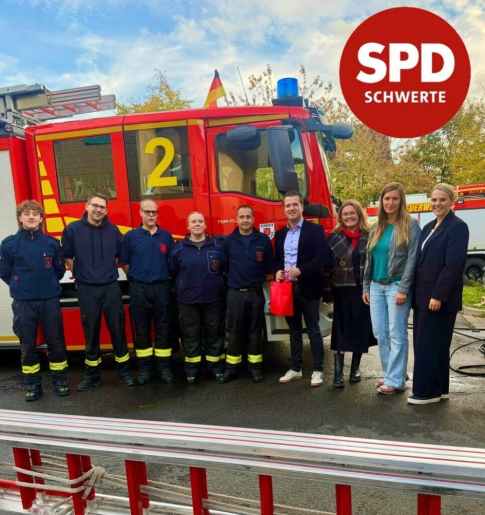 Einsatzkräfte der Feuerwehr Schwerte und SPD-Vertreterinnen und -Vertreter vor einem Löschfahrzeug